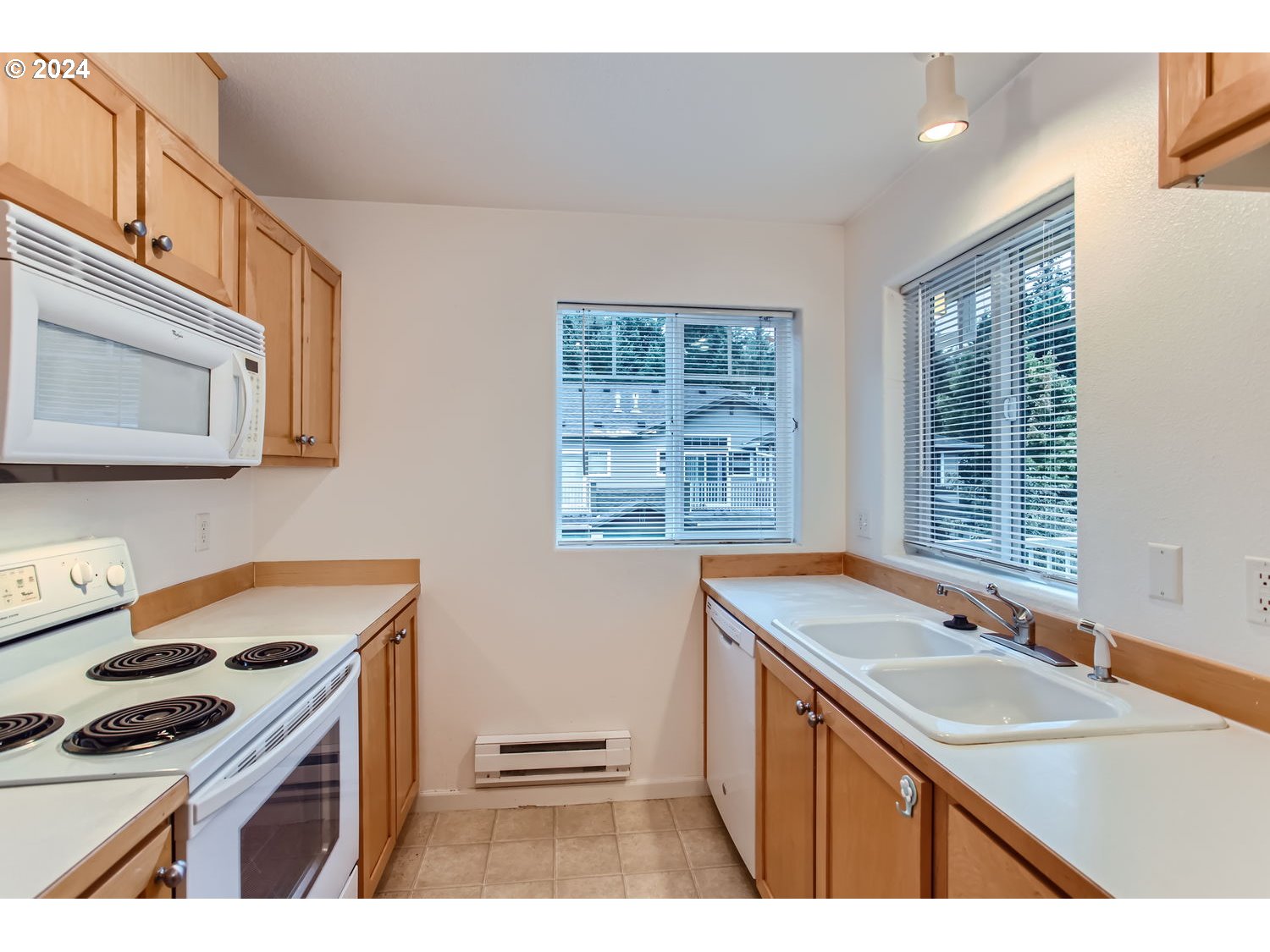 14740 Southwest Sandhill Loop, Unit 203 Beaverton, OR 97007 - Photo 16 of 35 a kitchen that has a sink a stove and a wooden floor
