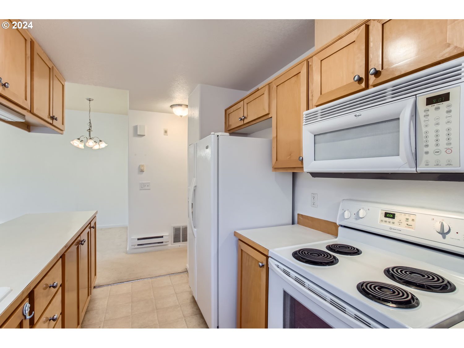 14740 Southwest Sandhill Loop, Unit 203 Beaverton, OR 97007 - Photo 18 of 35 a kitchen with stainless steel appliances granite countertop a stove a refrigerator and a microwave