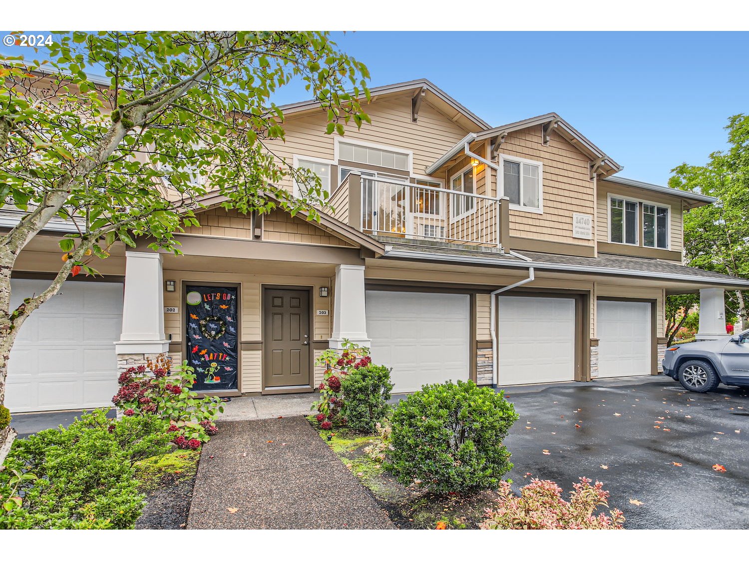 14740 Southwest Sandhill Loop, Unit 203 Beaverton, OR 97007 - Photo 4 of 35 a view of a white house with large windows and a small yard