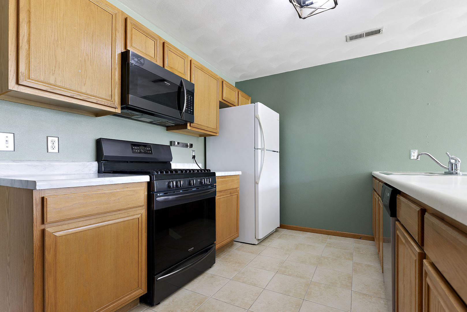 10050 Skipperling Road, Unit 1 Roscoe, IL 61073 - Photo 6 of 15 a kitchen with stainless steel appliances granite countertop a stove top oven microwave and refrigerator