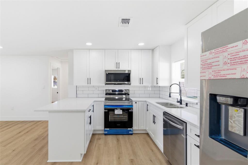 1448 South Belcher Road Largo, FL 33771 - Photo 14 of 47 a kitchen with cabinets stainless steel appliances a sink and a stove
