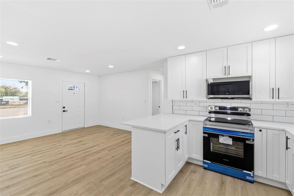 1448 South Belcher Road Largo, FL 33771 - Photo 15 of 47 a kitchen with granite countertop a stove top oven and sink