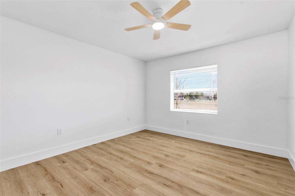 1448 South Belcher Road Largo, FL 33771 - Photo 19 of 47 an empty room with wooden floor and windows