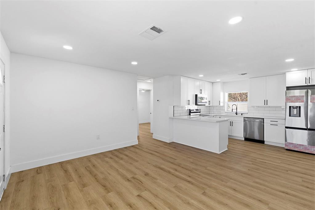 1448 South Belcher Road Largo, FL 33771 - Photo 6 of 47 a view of a kitchen with white cabinets wooden floor and a sink