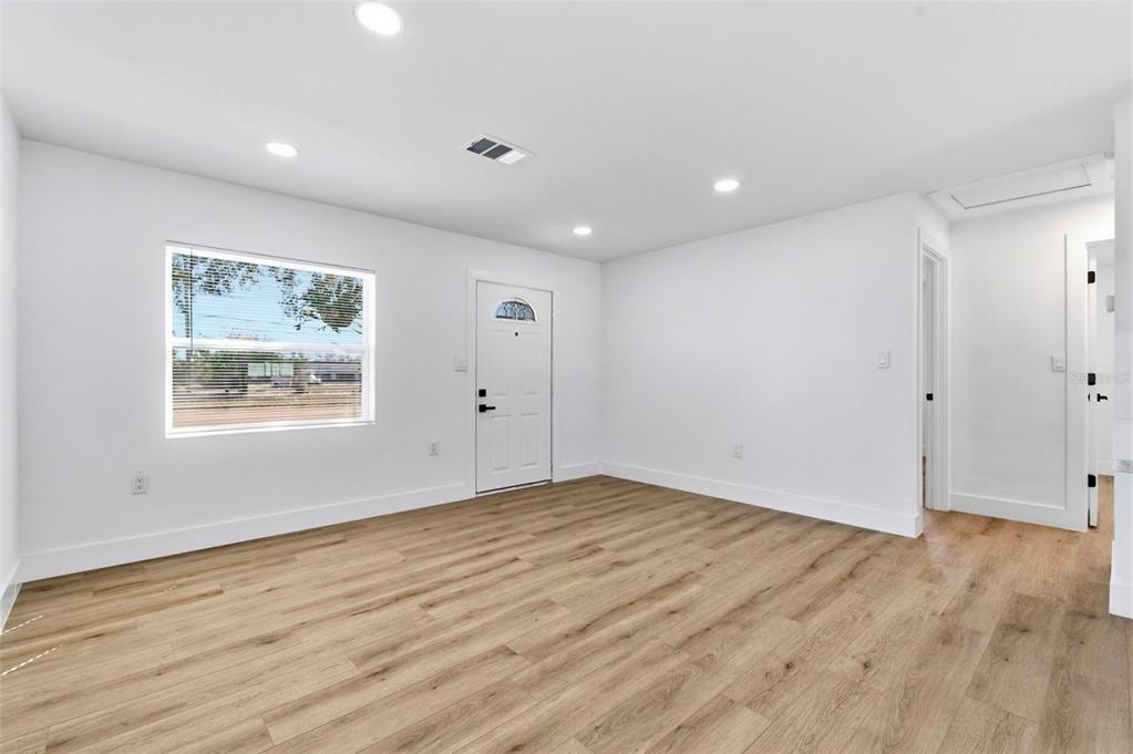 1448 South Belcher Road Largo, FL 33771 - Photo 7 of 47 a view of an empty room with wooden floor and window
