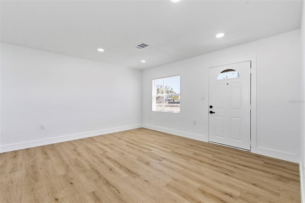 1448 South Belcher Road Largo, FL 33771 - Photo 8 of 47 an empty room with wooden floor and windows