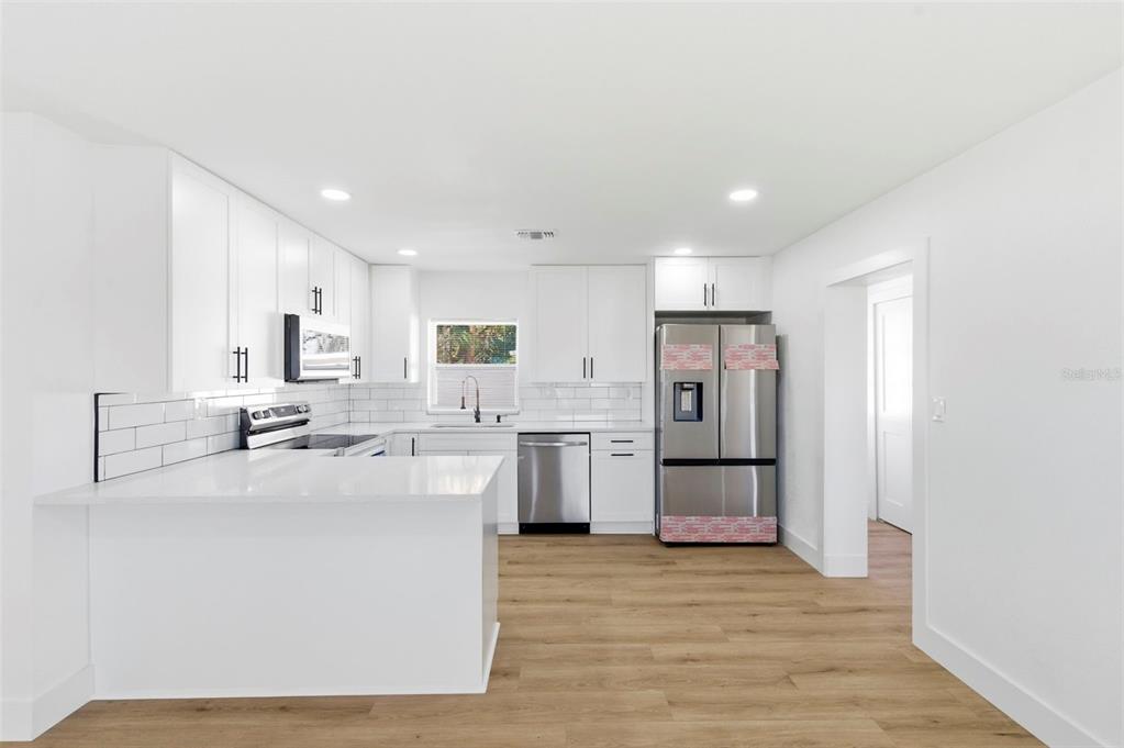 1448 South Belcher Road Largo, FL 33771 - Photo 9 of 47 a kitchen with refrigerator and cabinets