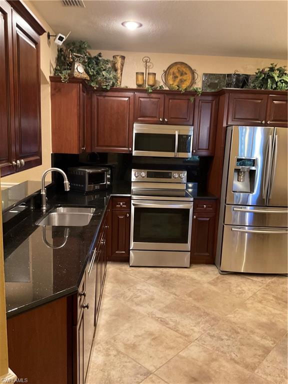 17560 Brickstone Loop Fort Myers, FL 33967 - Photo 3 of 25 a kitchen with stainless steel appliances a stove a sink and a microwave