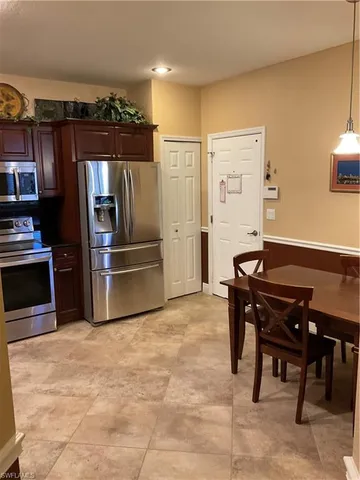 a kitchen with granite countertop a refrigerator and a stove top oven