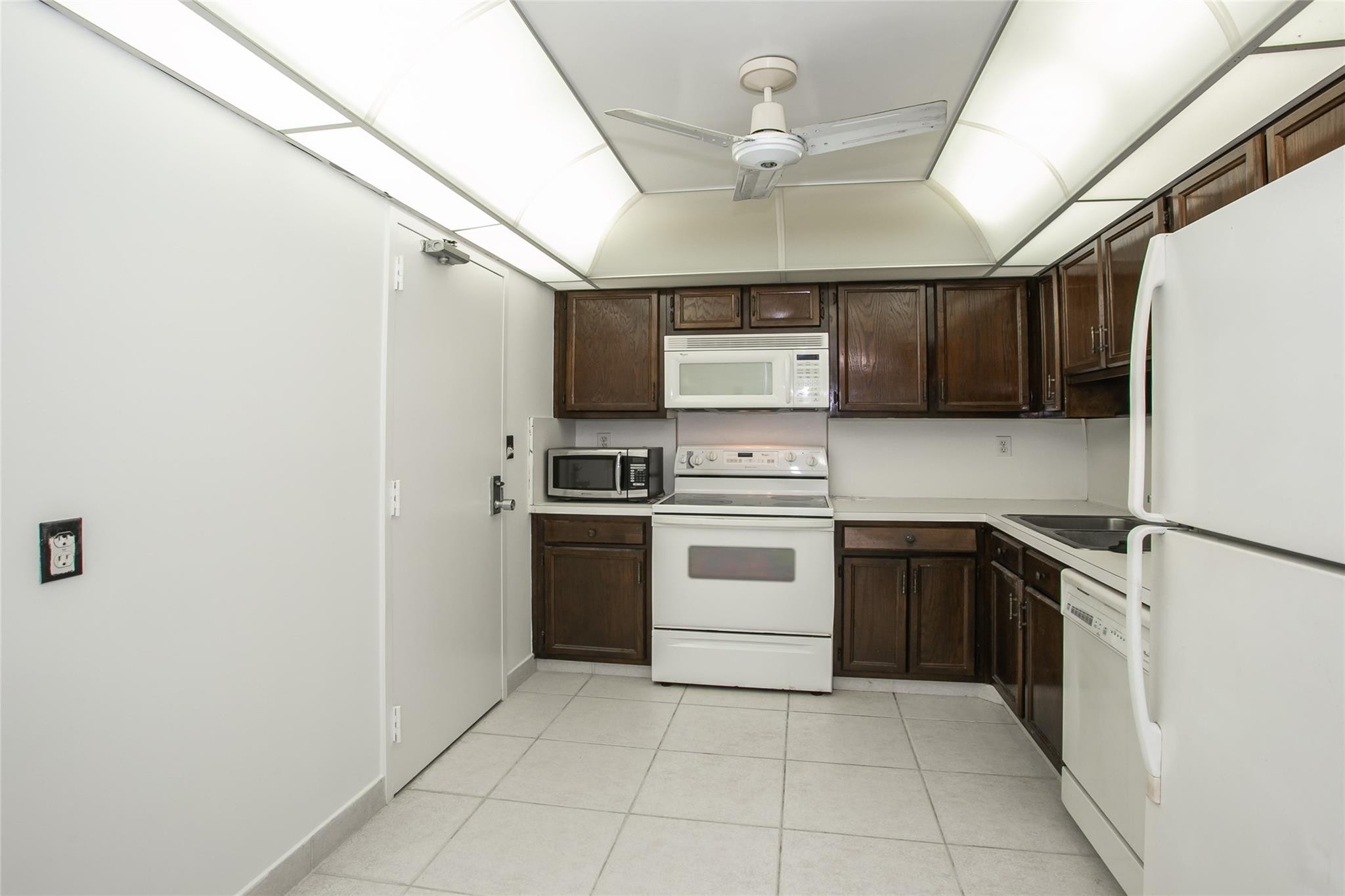10777 West Sample Road, Unit 718 Coral Springs, FL 33065 - Photo 13 of 16 a kitchen with a stove cabinets and a refrigerator