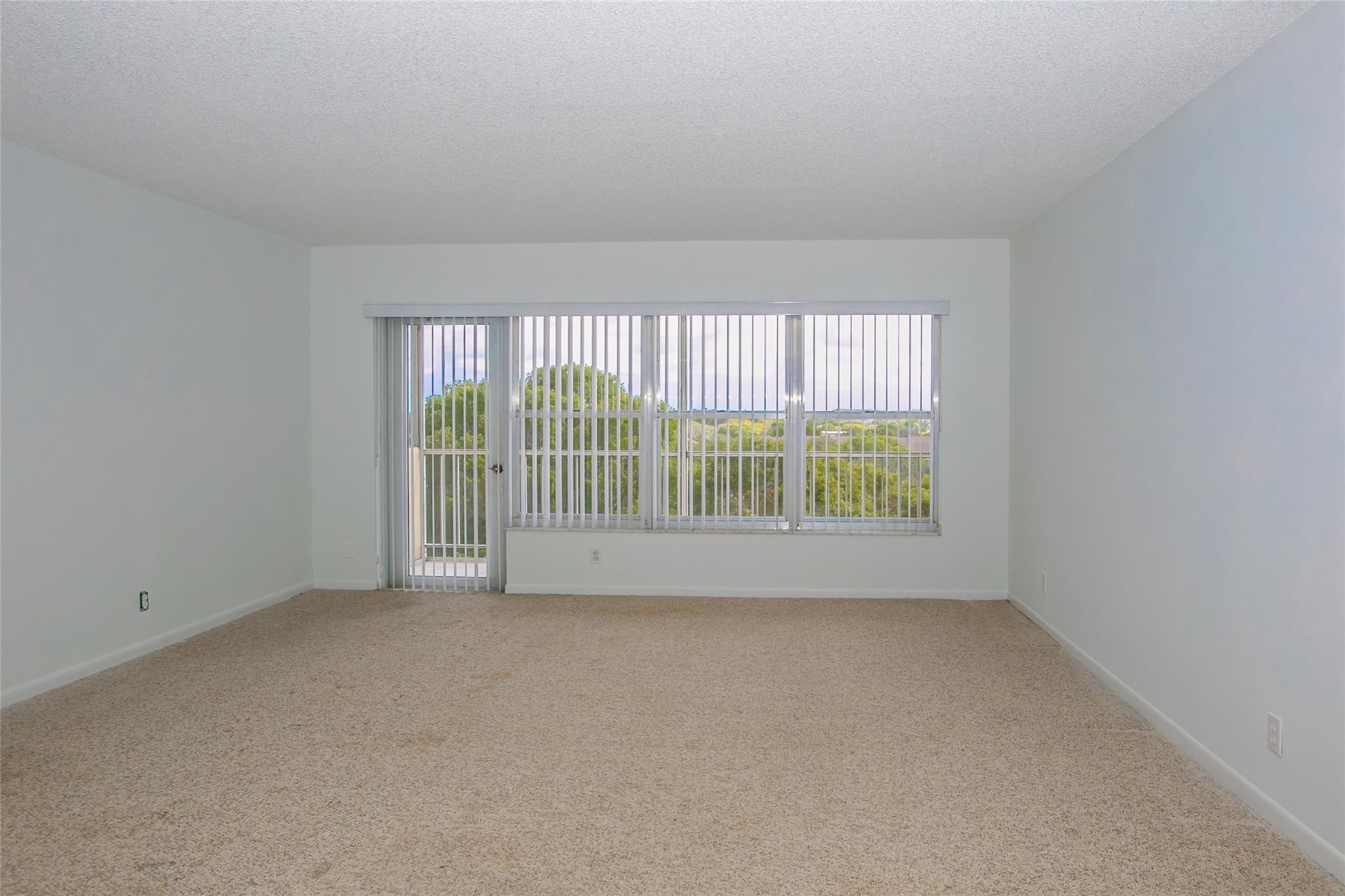 10777 West Sample Road, Unit 718 Coral Springs, FL 33065 - Photo 5 of 16 an empty room with windows