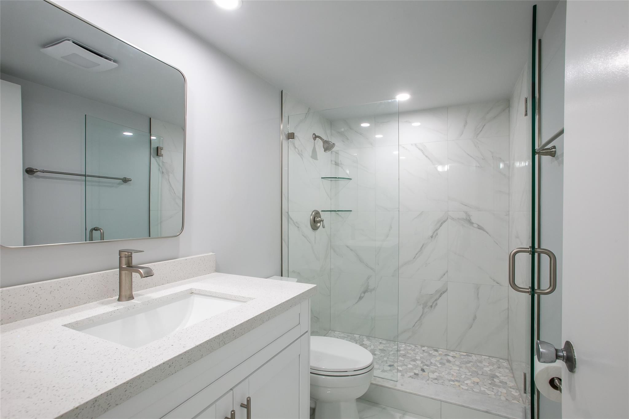 10777 West Sample Road, Unit 718 Coral Springs, FL 33065 - Photo 8 of 16 a bathroom with a sink toilet vanity and shower