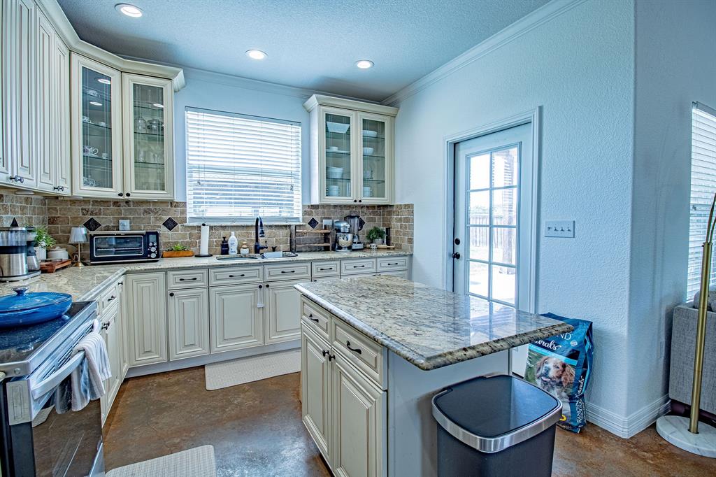 328 Meadow Lane Red Oak, TX 75154 - Photo 8 of 35 Kitchen featuring decorative backsplash, glass insert cabinets, light stone counters, stainless steel electric stove, and ornamental molding