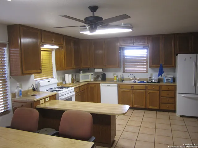 a kitchen with stainless steel appliances kitchen island granite countertop a sink and a refrigerator