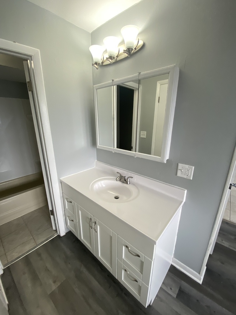 29837 Highway 50, Unit E1 Peotone, IL 60468 - Photo 12 of 17 a bathroom with a sink a mirror and a toilet