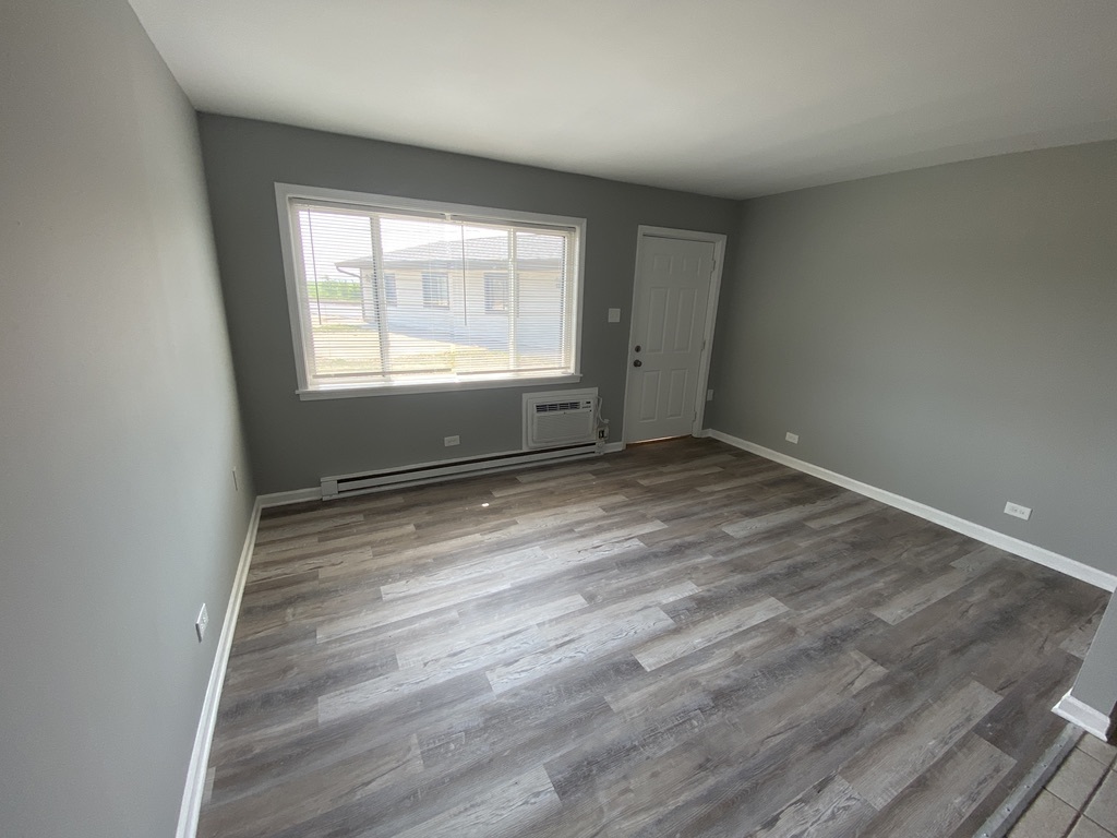 29837 Highway 50, Unit E1 Peotone, IL 60468 - Photo 5 of 17 wooden floor in an empty room with a window