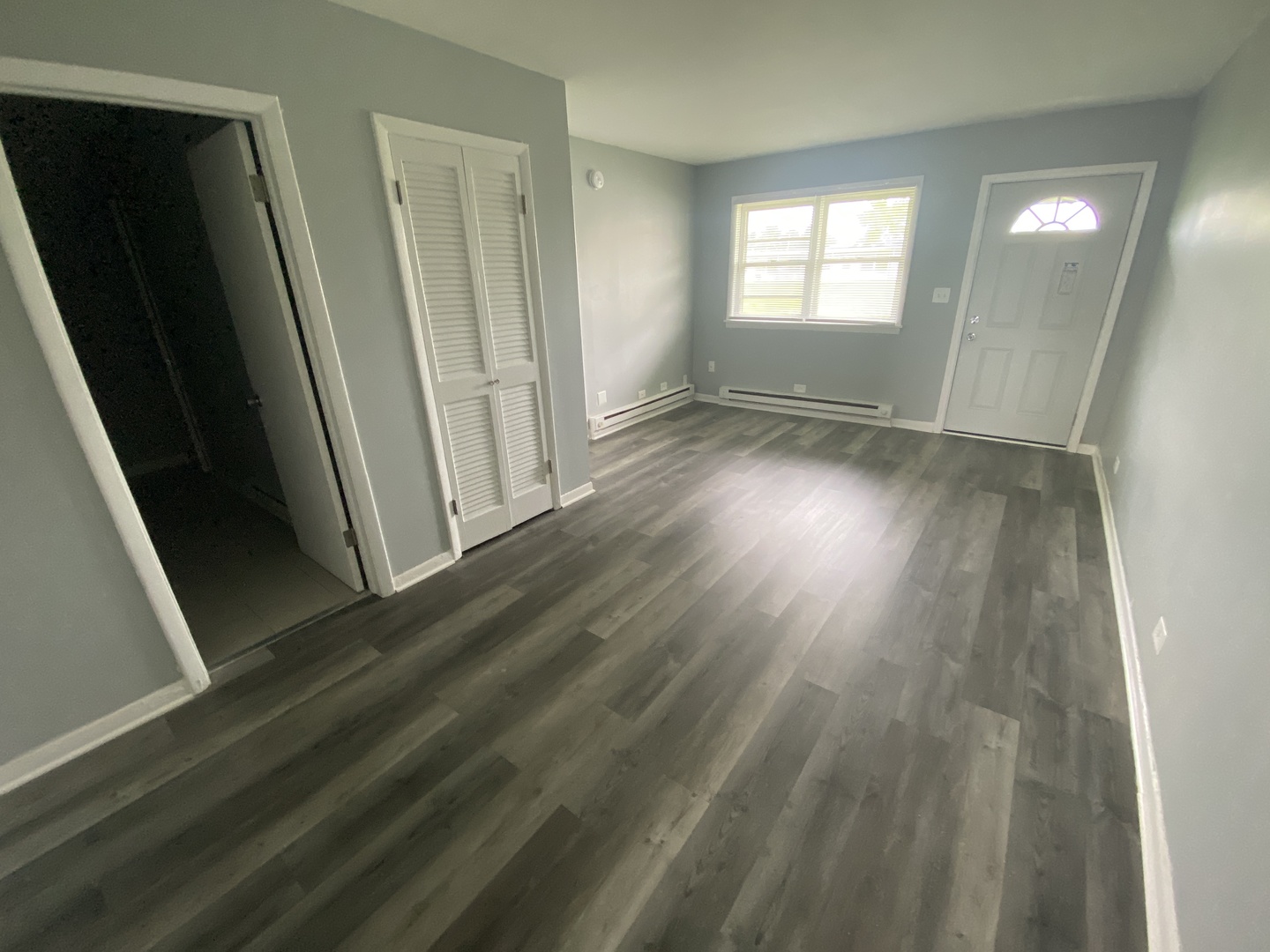 29837 Highway 50, Unit E1 Peotone, IL 60468 - Photo 7 of 17 an empty room with wooden floor and windows