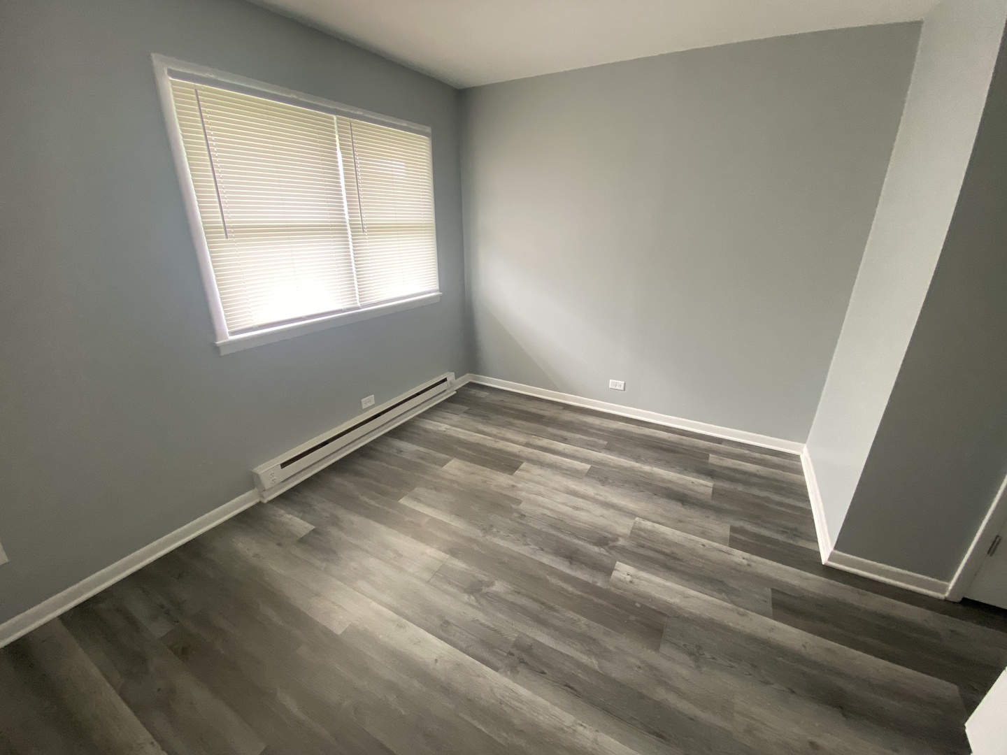 29837 Highway 50, Unit E1 Peotone, IL 60468 - Photo 9 of 17 a view of an empty room with wooden floor and a window