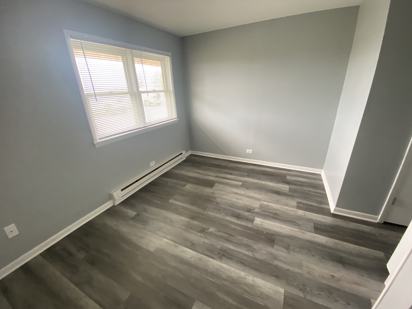 29837 Highway 50, Unit E1 Peotone, IL 60468 - Photo 10 of 17 an empty room with wooden floor and windows