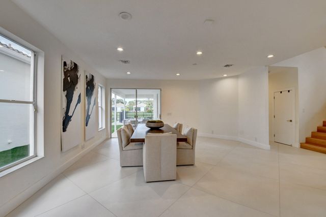 a dining room with furniture and a floor to ceiling window
