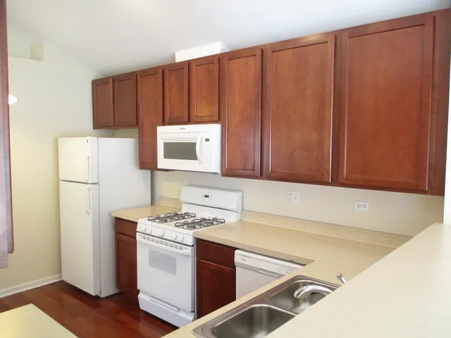 a kitchen with wooden cabinets and white appliances