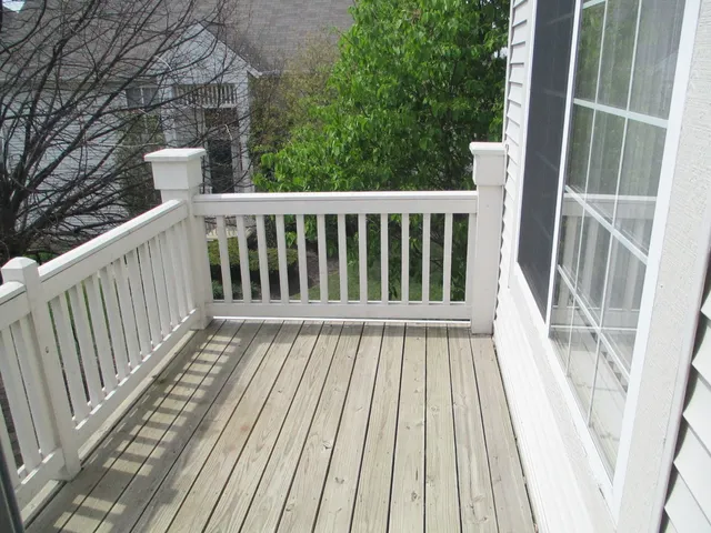 a view of balcony with wooden floor and fence
