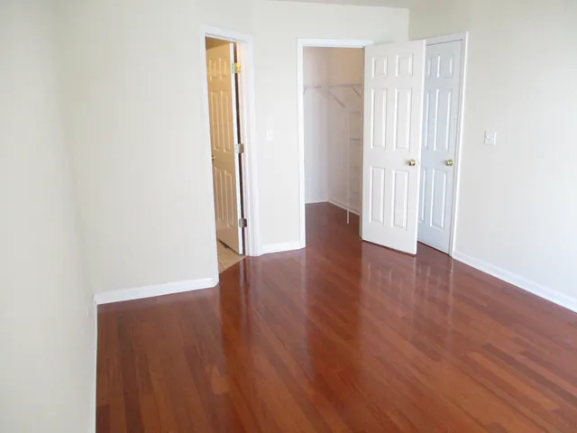 an empty room with wooden floor and closet