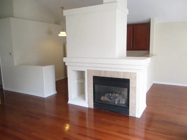 a living room with a fireplace and wooden floor