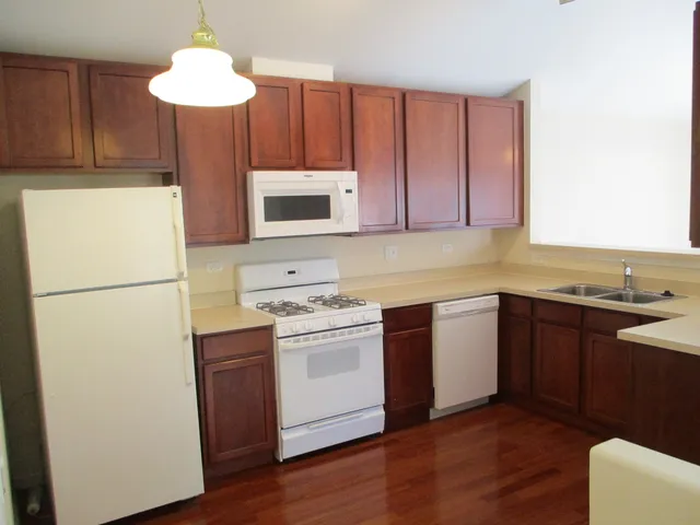 a kitchen with stainless steel appliances granite countertop a refrigerator a sink dishwasher a stove with wooden floor