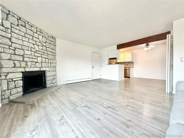 a view of empty room with wooden floor and fireplace