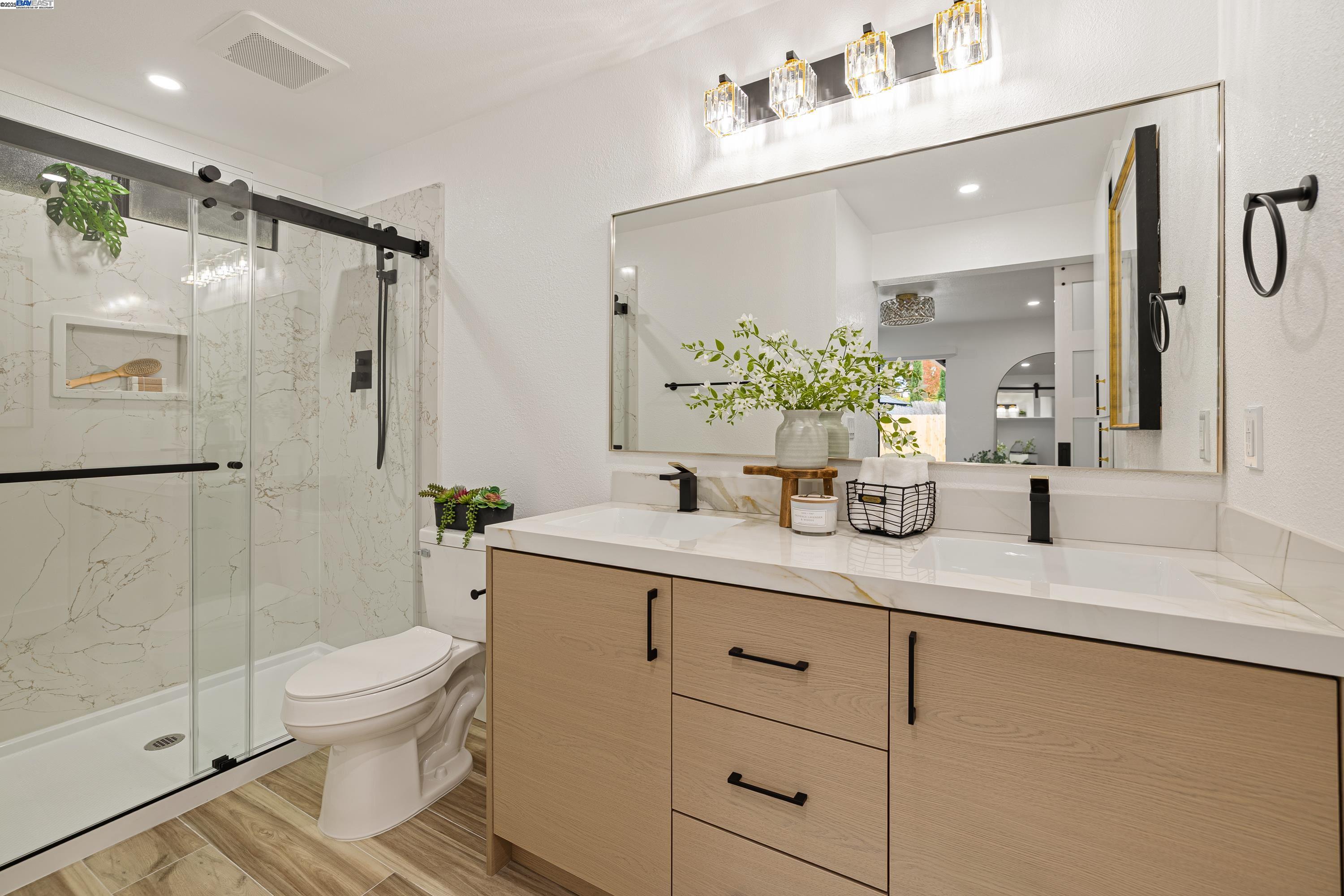 713 Sandy Brook Court Rodeo, CA 94572 - Photo 25 of 36 a bathroom with a granite countertop sink a toilet a mirror and shower