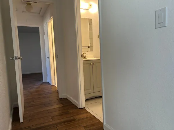a view of a hallway with wooden floor