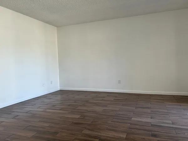 a view of an empty room and wooden floor