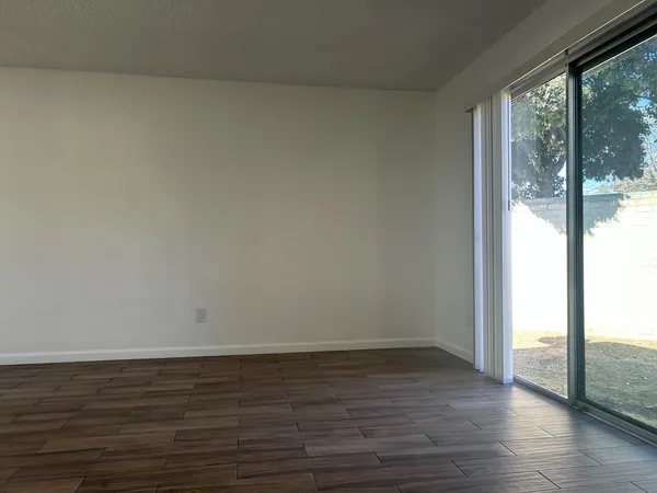 a view of an empty room and wooden floor and windows