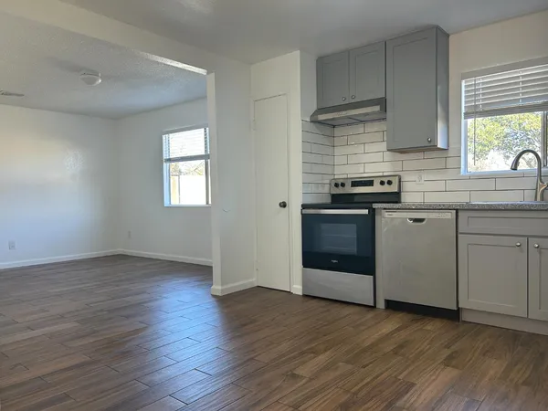 a kitchen with wooden floors and appliances