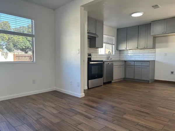 a kitchen with stainless steel appliances granite countertop a stove a sink and a refrigerator