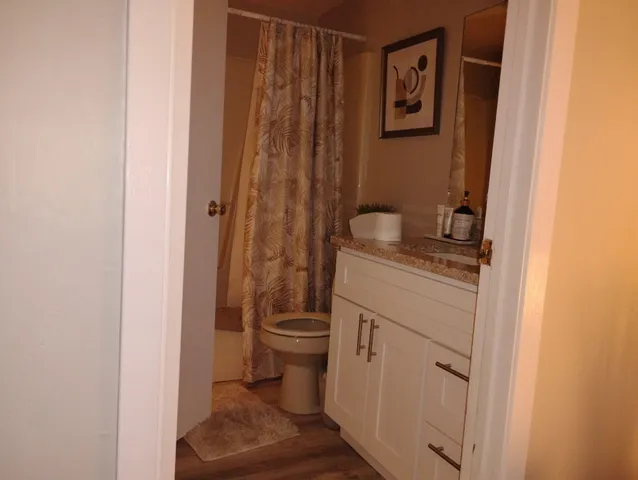 a bathroom with a granite countertop sink toilet and shower