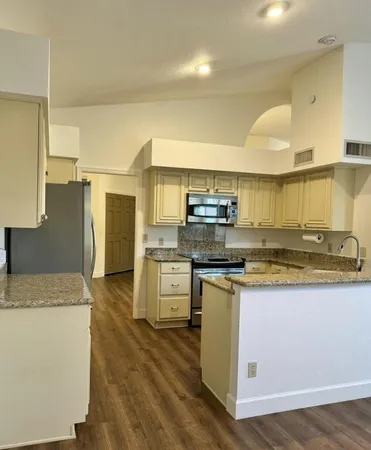 a kitchen with stainless steel appliances granite countertop a stove a sink and a refrigerator