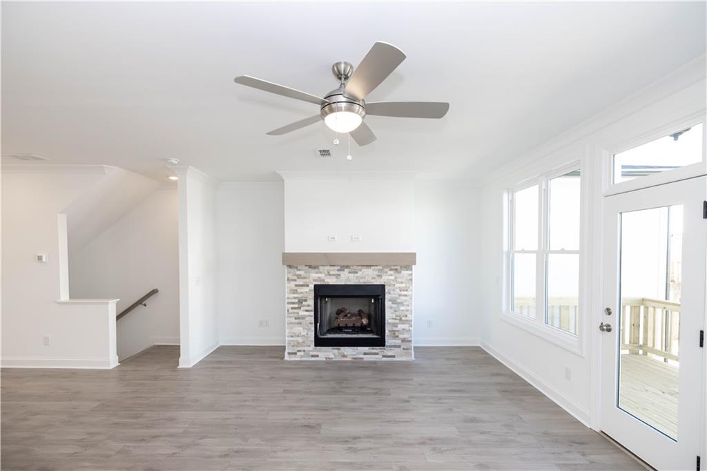 629 Silva Street, Unit 128 Cumming, GA 30040 - Photo 12 of 54 a view of an empty room with chandelier fan and wooden floor