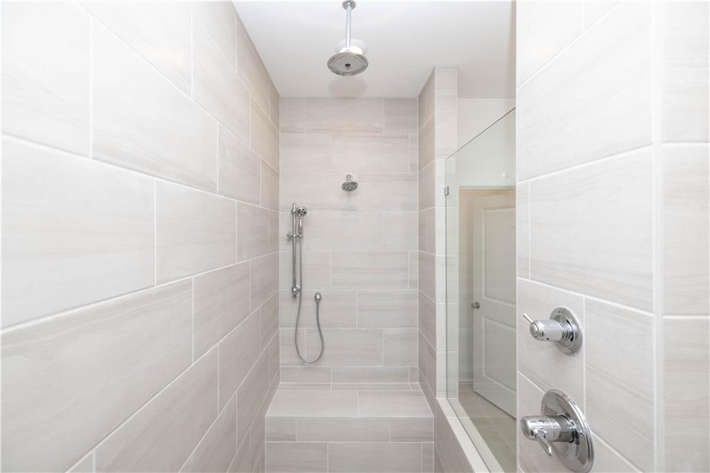 629 Silva Street, Unit 128 Cumming, GA 30040 - Photo 18 of 54 a bathroom with a glass shower door