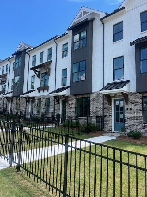 629 Silva Street, Unit 128 Cumming, GA 30040 - Photo 3 of 54 a view of a brick house with many windows
