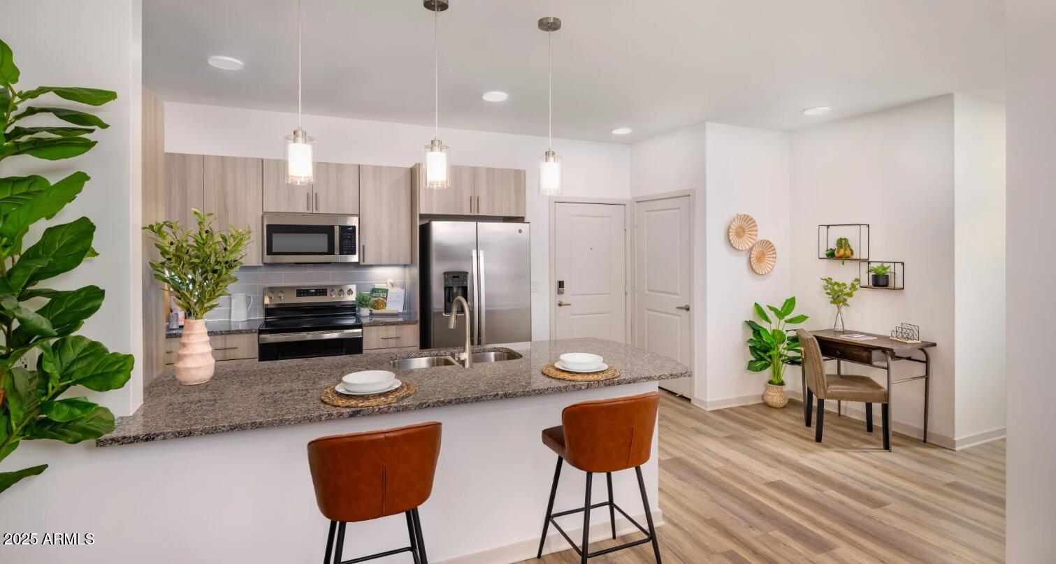 3545 East Warner Road, Unit 1 Gilbert, AZ 85296 - Photo 3 of 14 a kitchen with stainless steel appliances kitchen island granite countertop a refrigerator and a dining table
