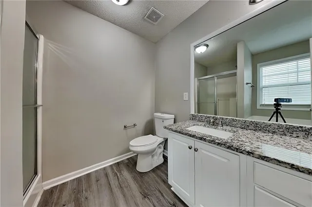 a bathroom with a granite countertop sink a toilet and a mirror