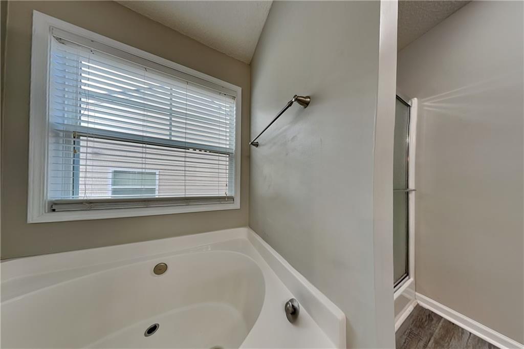 3762 Plymouth Rock Drive Loganville, GA 30052 - Photo 15 of 28 a bathroom with a tub and a shower