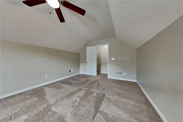 a view of a room with a ceiling fan and window