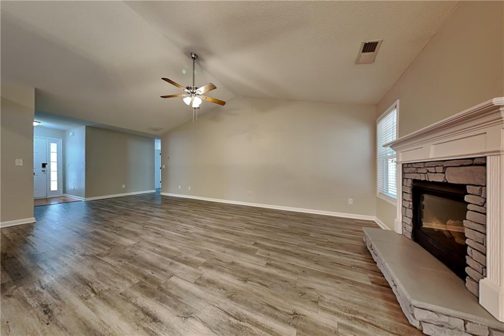 3762 Plymouth Rock Drive Loganville, GA 30052 - Photo 4 of 28 a view of an empty room with wooden floor fireplace and a window