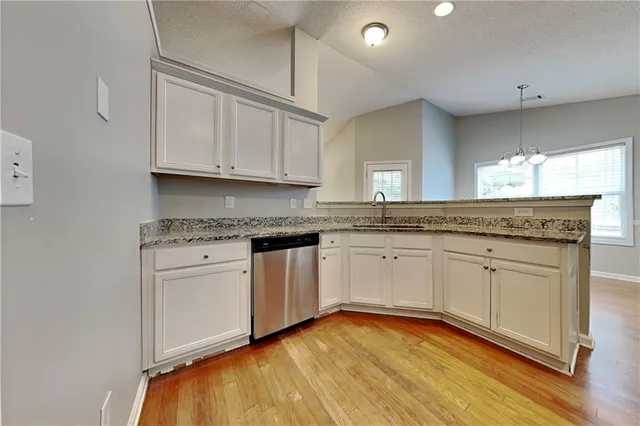 a kitchen with granite countertop white cabinets and white appliances