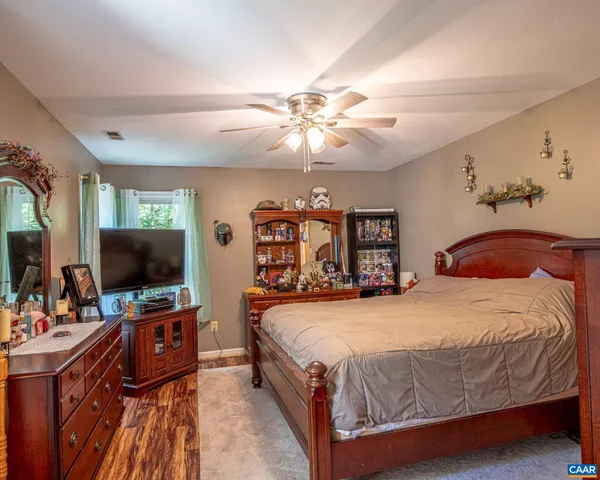 a bedroom with a bed and a flat tv screen on dresser