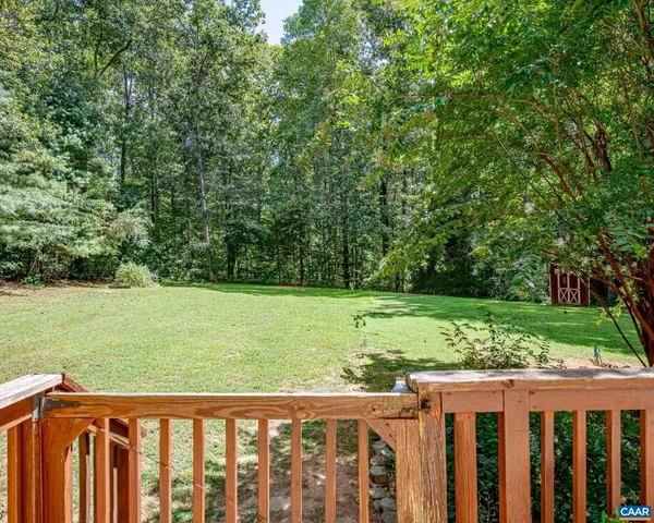 a view of a green field with wooden fence