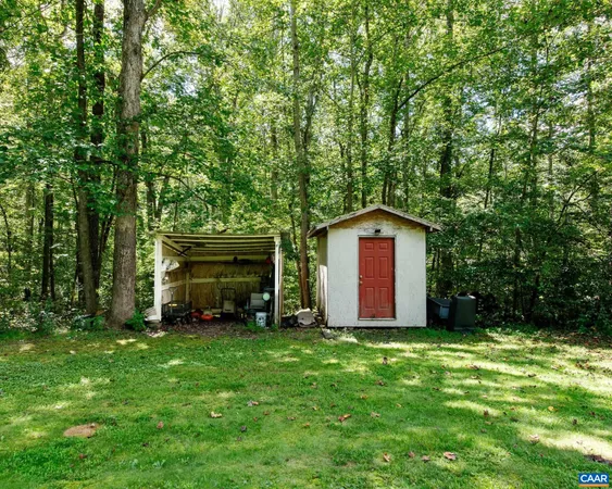 a view of a house with a big yard and large trees
